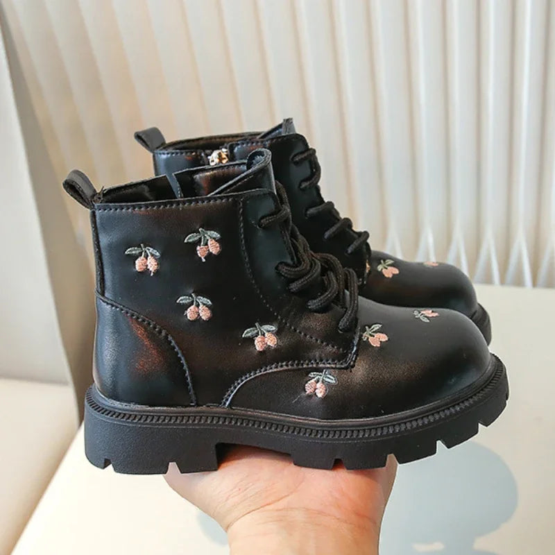 Schwarze Kinderstiefel aus glänzendem Material mit Blumenmuster, ideal für den täglichen Gebrauch.